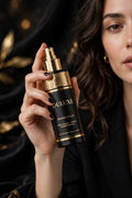 Flacon spray identificateur de duvet facial DULUXE noir et doré tenu par une femme, visuel principal beauté