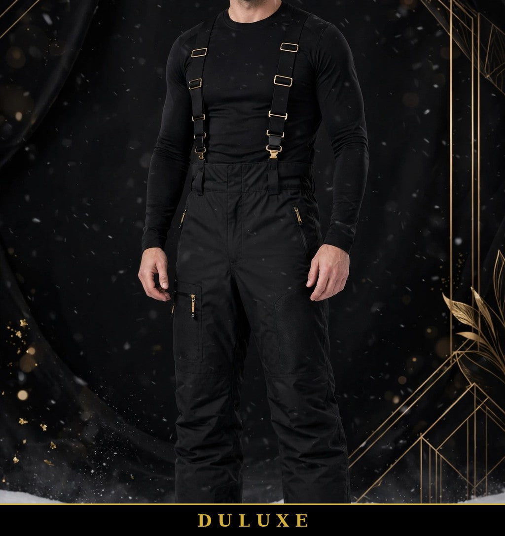 Homme portant le pantalon de neige noir DULUXE à bretelles ajustables dans la neige