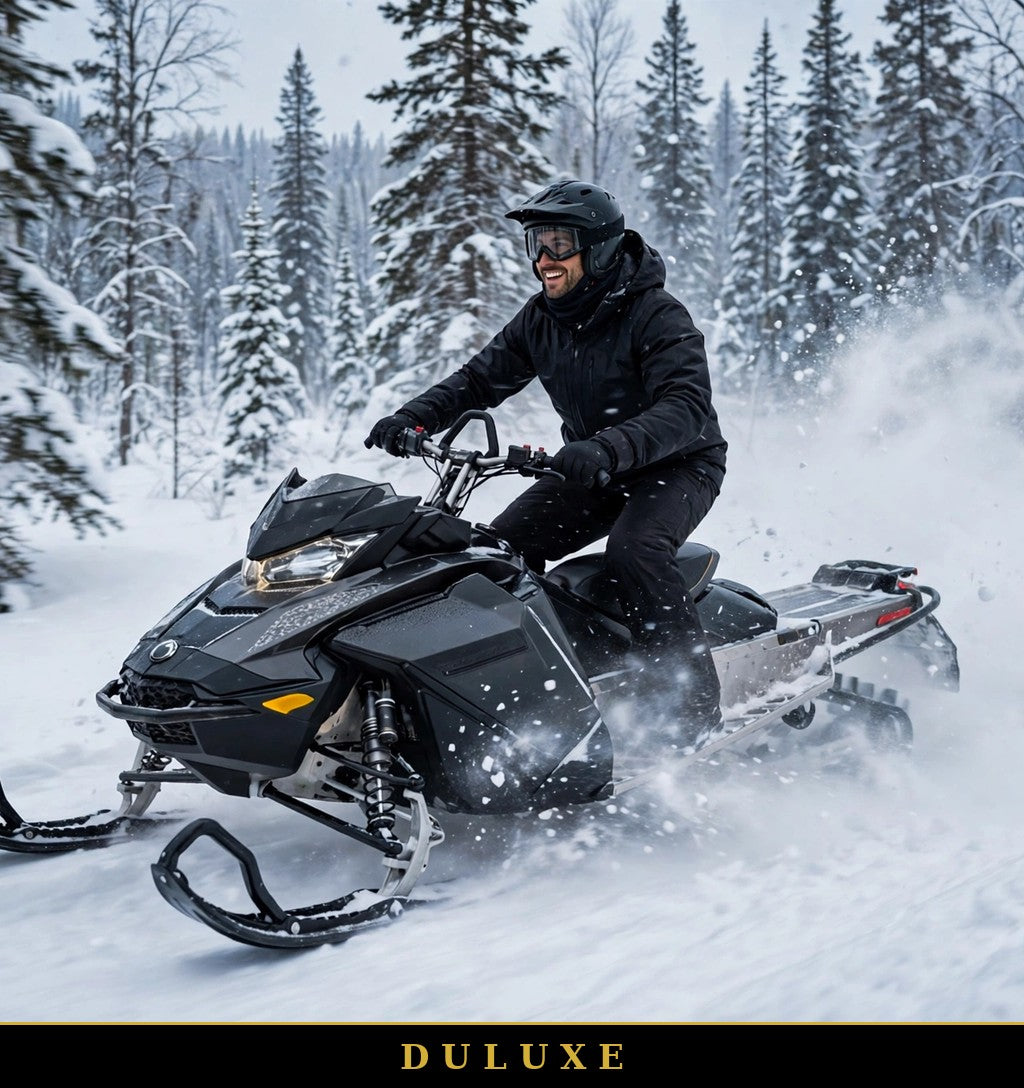 Homme en pantalon de neige noir DULUXE en motoneige en forêt enneigée