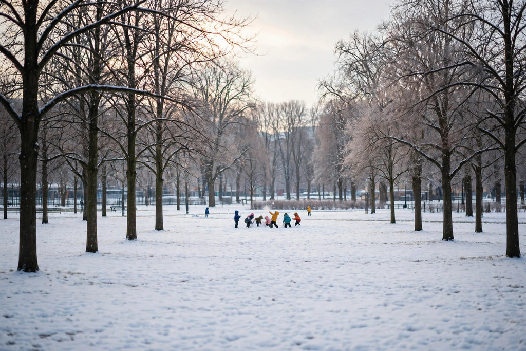 Enfants jouant dans la neige au loin, doudounes d'hiver à capuche bien visibles dans le paysage hivernal