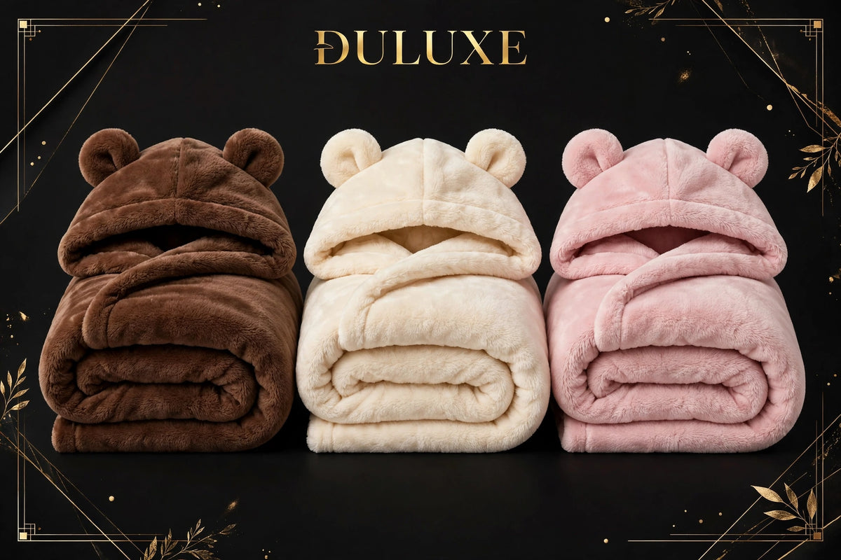 Les trois coloris du plaid à capuche ours douillet pliés : brun ours, crème et rose poudré, sur fond noir et doré