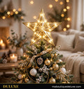 Étoile de sapin lumineuse dorée DULUXE scintillante au sommet d'un sapin de Noël décoré dans un salon chaleureux