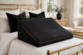 Coussin de Position Multifonction en Mousse à Mémoire DULUXE noir avec liseré doré, sur un lit premium