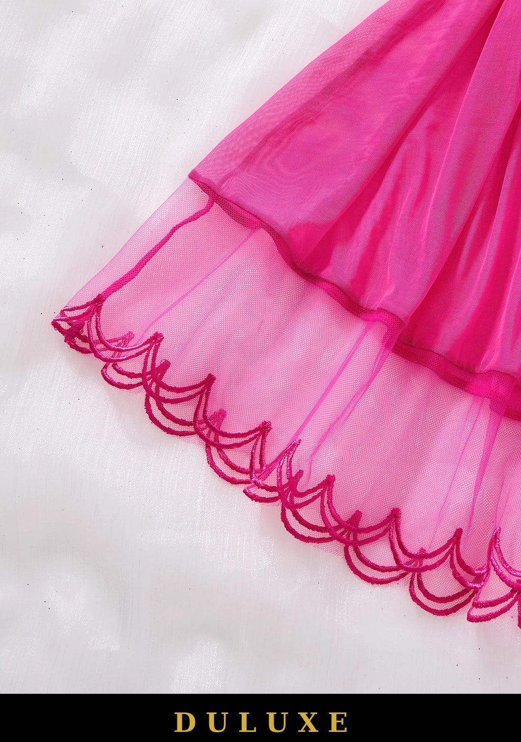 Détail de l'ourlet festonné brodé du voile rose fuchsia de la nuisette babydoll DULUXE