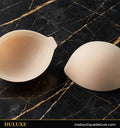 Soutiens-gorge adhésifs invisibles beige DULUXE sur marbre noir et doré, visuel principal