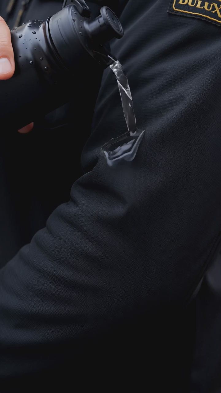 Démonstration vidéo : eau qui perle sur le tissu softshell, veste portée sous pluie fine