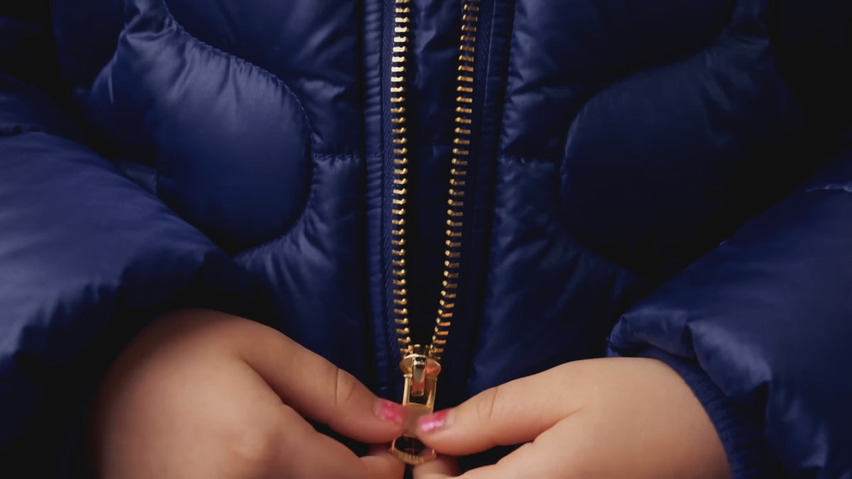 Vidéo de démonstration en français : gros plan sur le gonflant, la capuche et le zip facile à fermer de la doudoune pour enfant